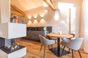 a dining room with a table and chairs and a fireplace at Seeheimat Ferienwohnungen in Schliersee