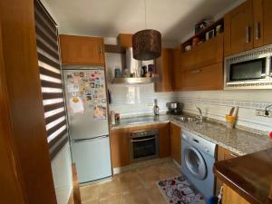 a kitchen with a white refrigerator and a dishwasher at Vivienda turistica Pop Bowie House in Úbeda