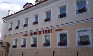 a white building with flower boxes on the windows at Sibirian Tourist in Perm