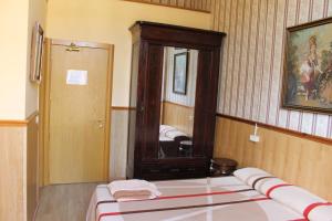 - une chambre avec un lit et un grand miroir dans l'établissement Pensión Villanueva, à Barcelone