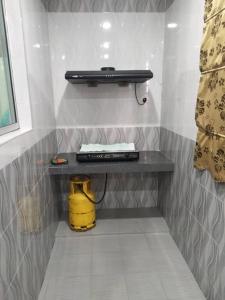 a shelf on a wall with a radio and a yellow bucket at Idham Homestay in Ipoh