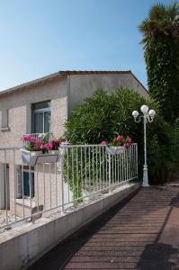 a fence with two flowerpots on it next to a building at Le Pavillon Bleu Hotel Restaurant in Royan