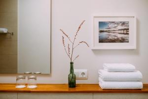 a vase with flowers in it on a table with towels at el gran sueño Boutique Hotel & Apartamentos - Adults Only in Pintueles