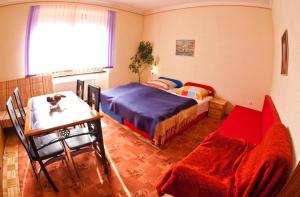a bedroom with a bed and a table and a chair at Guest House Pikapolonca in Maribor