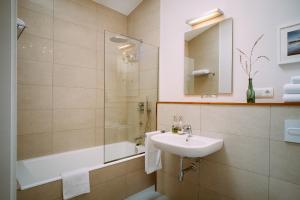 a bathroom with a sink and a shower and a tub at el gran sueño Boutique Hotel & Apartamentos - Adults Only in Pintueles