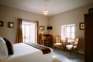 a bedroom with a bed and a table and chairs at el gran sueño Boutique Hotel & Apartamentos - Adults Only in Pintueles