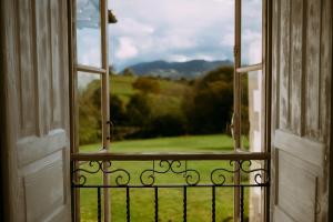 an open window with a view of a green field at el gran sueño Boutique Hotel & Apartamentos - Adults Only in Pintueles