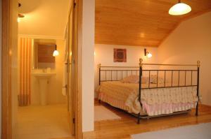 ein Schlafzimmer mit einem Bett und ein Badezimmer mit einem Waschbecken in der Unterkunft Casa Avó Alice in Seia