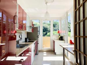 eine Küche mit roten Schränken und einem großen Fenster in der Unterkunft La Terrazza di Isabel in Rom