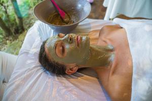 a man laying on a bed with a mask on his face at Villa Experience - Relais Il Termine Elba in Rio Marina