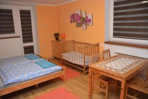 een kamer met een wieg en een tafel en een wieg bij Privat Alexandra in Liptovský Mikuláš