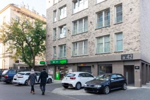 dwie osoby idące ulicą przed budynkiem w obiekcie Apartment NEARTO Old Town Miodowa Parking w Krakowie