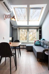 a living room with a couch and a table and windows at Apartment NEARTO Old Town Miodowa Street in Krakow