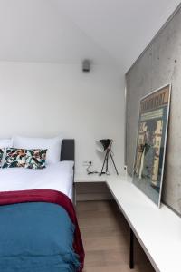 sypialnia z białym łóżkiem i białą ławką w obiekcie Apartment NEARTO Old Town Miodowa Parking w Krakowie