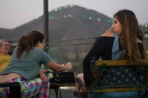 una mujer sentada en una silla junto a una chica en Hotel Iris en Salta