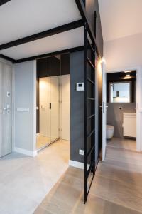 Pokój z przesuwnymi szklanymi drzwiami i łazienką w obiekcie Apartment NEARTO Old Town Miodowa Parking w Krakowie