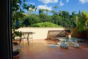 eine Terrasse mit einer Bank, einem Tisch und Stühlen in der Unterkunft La Terrazza di Isabel in Rom