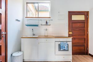 a small white kitchen with a sink and a window at Riverside City Centre Apartments in Porto +74 photos