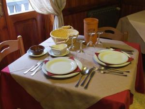 a table with plates and utensils on a table at Hotel Lysjoch in Gressoney-la-Trinité