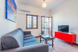 een woonkamer met een bank en een tv bij Riverside City Centre Apartments in Porto