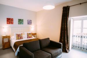 a bedroom with a bed and a couch and a window at el gran sueño Boutique Hotel & Apartamentos - Adults Only in Pintueles