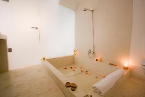 a white bathroom with a bath tub with a shower at Riad El Maâti in Rabat