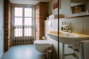 uma casa de banho com um lavatório, um WC e uma janela. em el gran sueño Boutique Hotel & Apartamentos - Adults Only em Pintueles