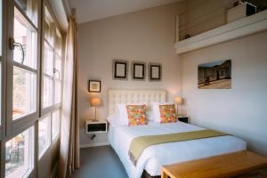 a bedroom with a white bed and a large window at el gran sueño Boutique Hotel & Apartamentos - Adults Only in Pintueles