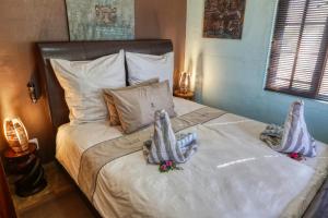 een slaapkamer met een bed met twee poppen erop bij Ijaba Lodge at Buschfeld Park in Outjo