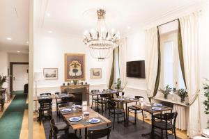 a dining room with tables and chairs and a chandelier at Relais Donna Lucrezia in Rome