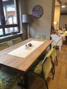 een eettafel met stoelen en een klok aan de muur bij Hotel Restaurant zum Schwanen in Bruchköbel