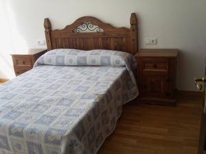 a bedroom with a bed with a blue and white quilt at Apartaments Pirinenc in Esterri d'Àneu
