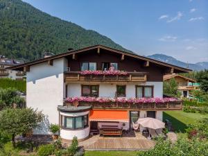 キルヒドルフ・イン・チロルにあるInviting Chalet in Kirchdorf in Tirol near City Centreの花の咲くバルコニー付きの家