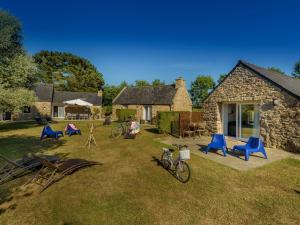 a yard with chairs and bikes parked in front of a house at Holiday home with private pool in Plouguin