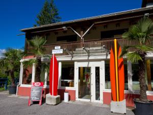 due tavole da surf rosse e arancioni davanti a un edificio di Appartements Popotnik a Faak am See
