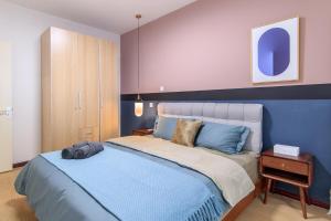 a bedroom with a large bed with a blue headboard at Tianjin·Hedong district·Excellence Building in Tianjin