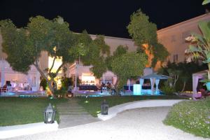 a building with tables and chairs in front of it at night at Relais Corte Degli Aragonesi in Ischia
