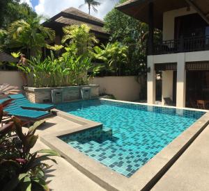 a swimming pool in front of a house at Large 4 bed villa short walk to Maenam beach in Mae Nam