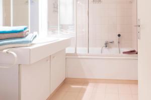 uma casa de banho branca com uma banheira e um lavatório em Studio à deux pas du Palais des Festivals em Cannes