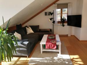 ein Wohnzimmer mit einem Sofa und einem Tisch in der Unterkunft Ferienwohnung Sandra Wetzel in Waltenhofen