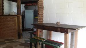 een houten tafel met vier krukken in een kamer bij Hospedaria Cumuruxatiba in Cumuruxatiba +68 foto's