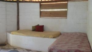 een bed in een kamer met een raam bij Hospedaria Cumuruxatiba in Cumuruxatiba