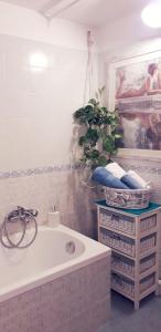 La salle de bains est pourvue d'une baignoire et d'une plante en pot. dans l'établissement Lo scrigno di Simon, à Senigallia