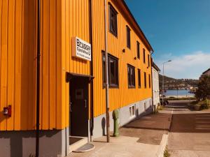 a yellow building with a sign on the side of it at Brygga Gjestehus in Harstad