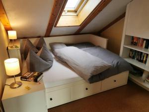 a bedroom with a bed with a window and a book shelf at Ferienwohnung Sandra Wetzel in Waltenhofen