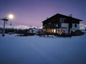 a building in the snow with a ski lift at Hotel Monte Triplex in Sauze dʼOulx