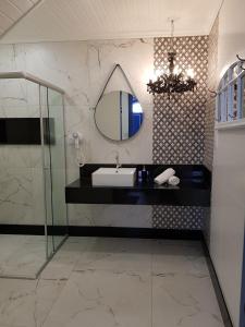 uma casa de banho com um lavatório e um espelho em Suíte Marília de Dirceu em Ouro Preto