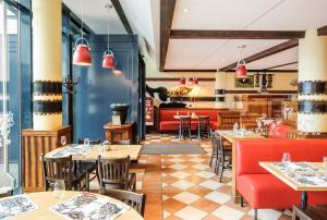 ein Restaurant mit Tischen und Stühlen und einer Bar in der Unterkunft ibis budget Genève Aéroport in Genf