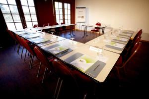 - une longue table dans une pièce avec des tables et des chaises dans l'établissement Campanile Evry Est - Saint Germain les Corbeil, à Saint-Germain-lès-Corbeil