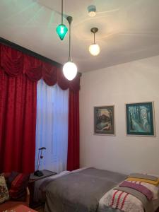 a bedroom with a bed and a window with red curtains at Villa Pazelt Top1 in Bad Vöslau